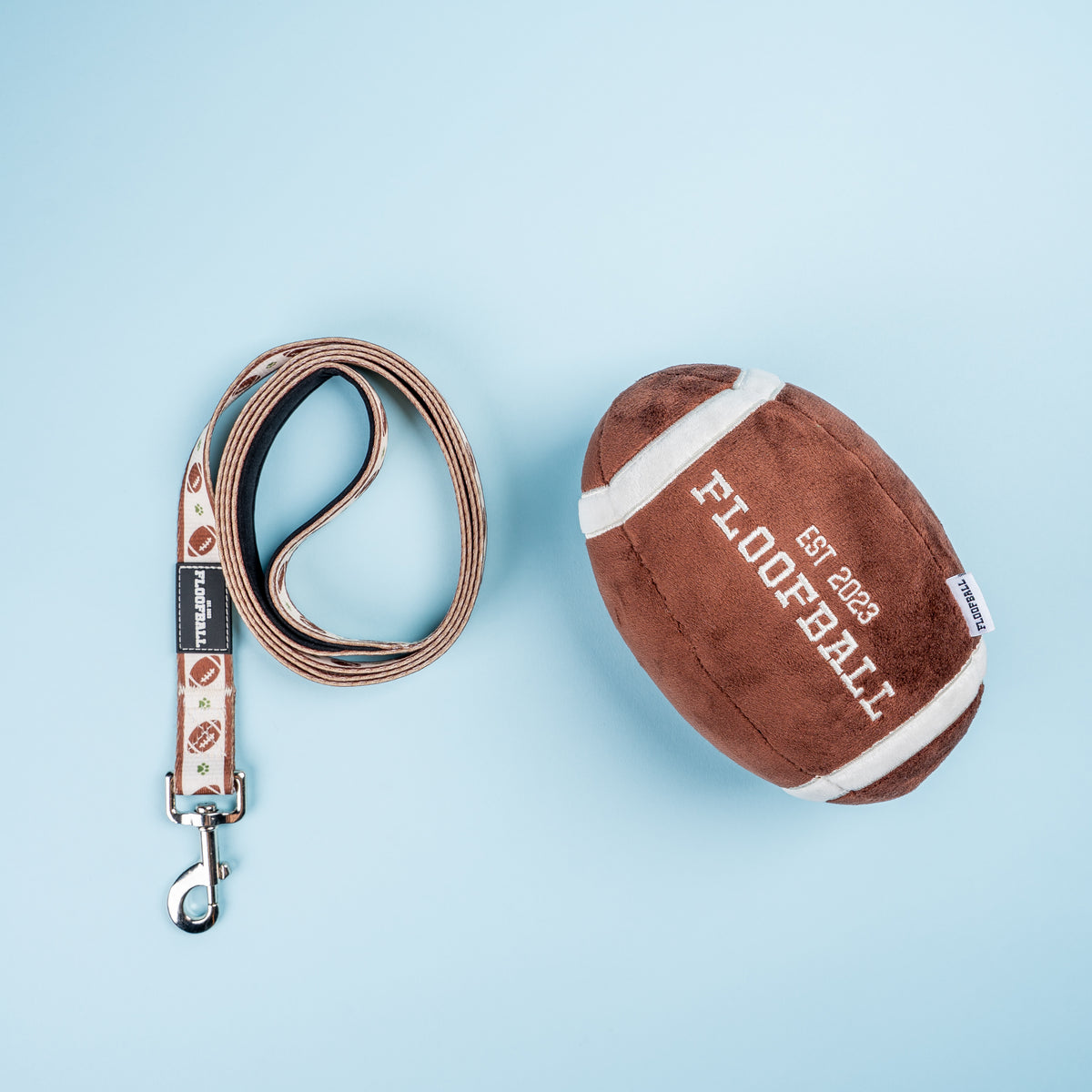 Floofball football dog collection featuring a football print dog leash and plush football dog toy on a blue background.