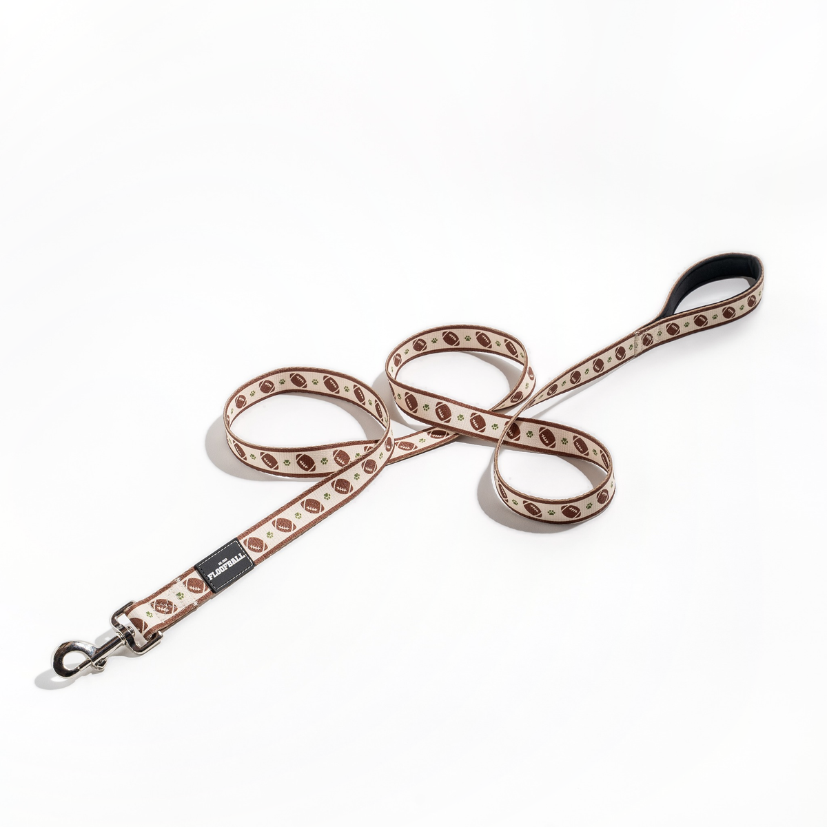 Full view of the Floofball football dog leash featuring a brown and cream football-inspired print, padded handle and metal clasp.